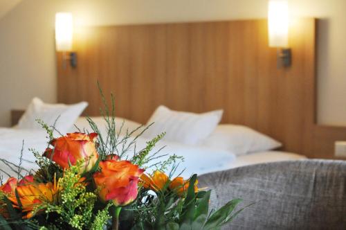 a hotel room with a bed and a bouquet of flowers at Hotel Fortuna in Stockach