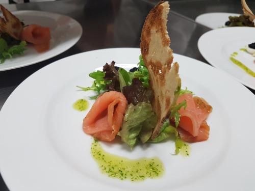 a white plate with a sandwich and salad on it at Hotel Starý Mlýn in Mlýnec