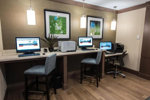 a office with four computers on a desk with chairs at Staybridge Suites Albany Wolf Rd-Colonie Center by IHG in Albany