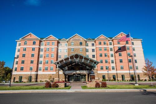 a large building with an american flag in front of it at Staybridge Suites Albany Wolf Rd-Colonie Center by IHG in Albany