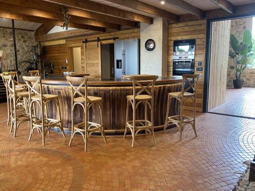 a bar with stools in a room with a kitchen at La Remise Penthouse in Le Somail