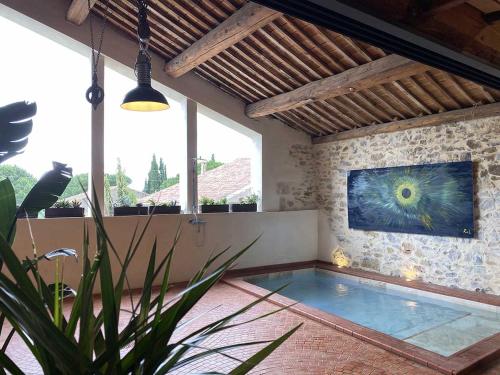 an indoor pool in a house with a painting on the wall at La Remise Penthouse in Le Somail