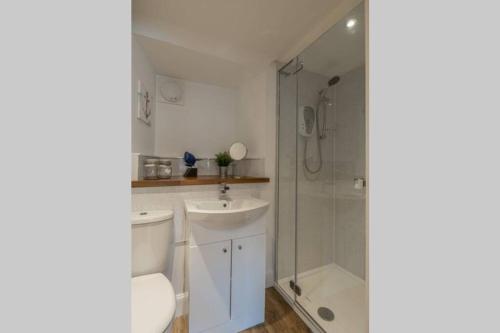 a white bathroom with a sink and a shower at Old Rope Store in Pittenweem