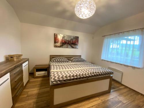 a bedroom with a bed and a chandelier at Vila Hanka in Lipno nad Vltavou