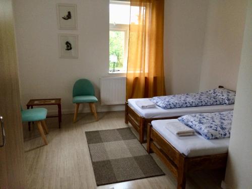 Cette petite chambre comprend 2 lits et une fenêtre. dans l'établissement Dzikówka, à Dzików Stary