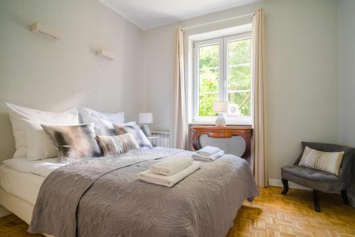1 dormitorio con 1 cama con ventana y silla en Ego Apartments Old Town, en Varsovia