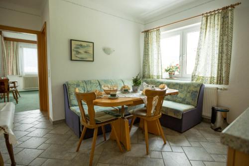 een woonkamer met een tafel en een bank bij Appartements Caroline in Ossiach