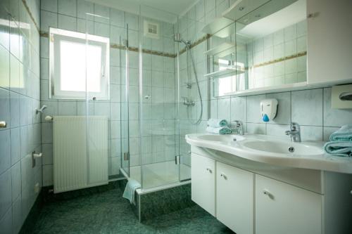 un bagno bianco con lavandino e doccia di Appartements Caroline a Ossiach