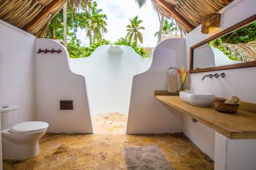 La salle de bains est pourvue de toilettes et d'un lavabo. dans l'établissement Gitana del Mar Boutique Beach Resort, à Buritaca