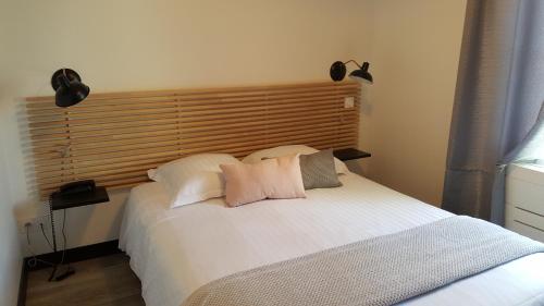 a bedroom with a white bed with two pillows at La Gourmandine in Châtellerault