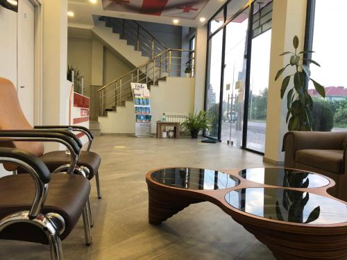 a lobby with a coffee table and chairs in a building at Hotel Royal Georgia in Batumi