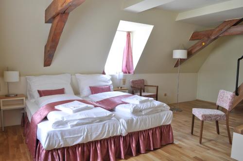 a bedroom with a large bed with white sheets at Penzion Lípa in Krásná Lípa