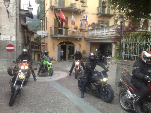 a group of people riding motorcycles on a street at Hotel Azalea in Baveno