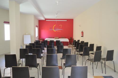 a room with chairs and a table and a red wall at Aparthotel El Cerrito in Los Cancajos