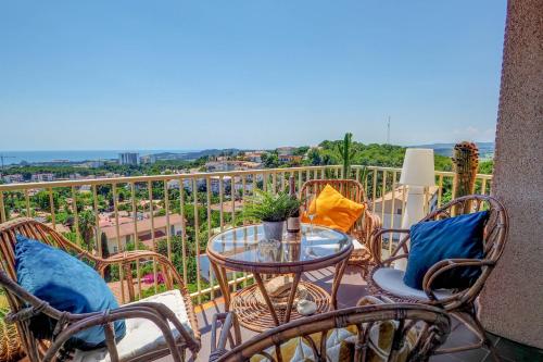 a balcony with chairs and a table with a view at Palma Fiesta Apartment by Hello Homes Sitges in Sant Pere de Ribes