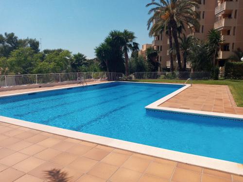 a swimming pool with blue water in a building at Palma Fiesta Apartment by Hello Homes Sitges in Sant Pere de Ribes