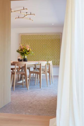 a dining room with a table with flowers on it at Les Pommiers in Ellezelles