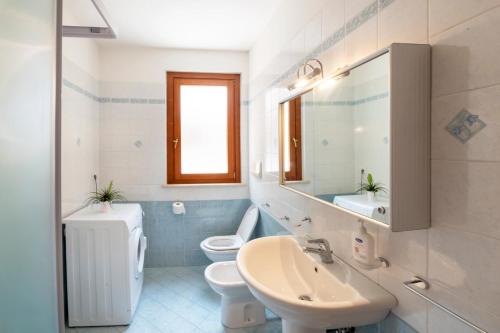 a bathroom with two toilets and a sink and a mirror at Marina Apartment in San Benedetto del Tronto