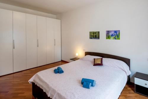 a bedroom with a large bed with blue slippers on it at Marina Apartment in San Benedetto del Tronto