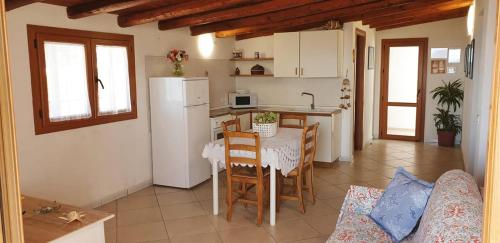 a kitchen with a table and a white refrigerator at Il Canneto di Selinunte in Marinella di Selinunte