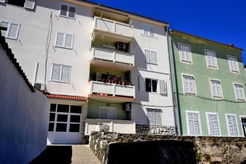 an apartment building with white and green at Rab City Apartment Greeny in Rab