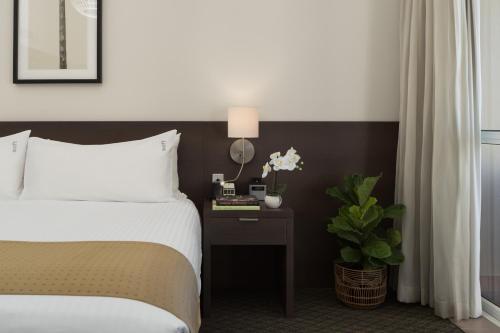 
a bedroom with a bed and a lamp at Holiday Inn Cairns Harbourside, an IHG Hotel in Cairns
