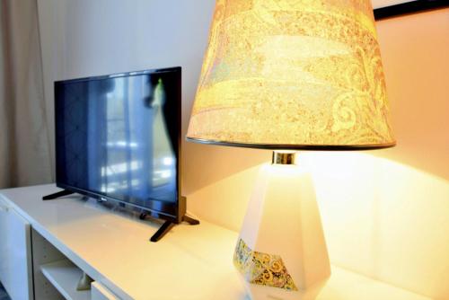 a lamp sitting on a desk with a tv at Rab City Apartment Greeny in Rab