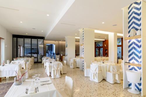 a dining room with white tables and white chairs at Hotel Mandetta - Adults Only in Paestum