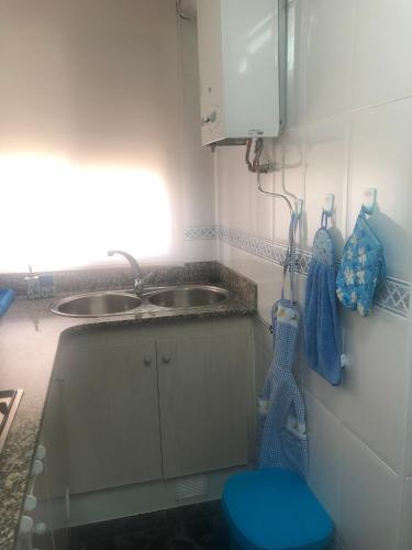 a small kitchen with a sink and a blue stool at Caseta del Delta de l'Ebre in Sant Jaume d'Enveja