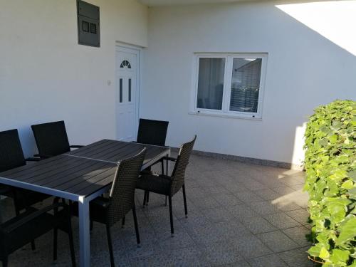 a table and chairs in a patio with a window at Apartmants Mazoljice in Mostar