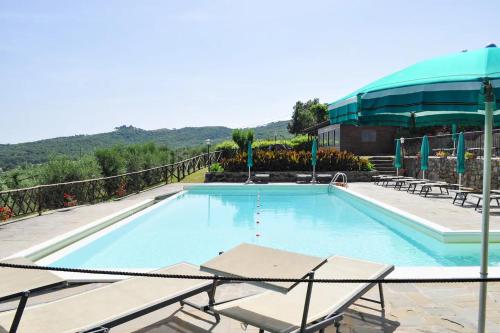 a large swimming pool with chairs and a building at Borgo Sanguineto in Tuoro sul Trasimeno