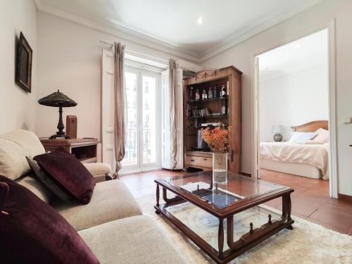 een woonkamer met een bank en een tafel bij Charmy Apartment Chueca's Square in Madrid
