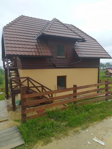 a house with a wooden fence in front of it at VILA PLANINSKI SAN in Sekulić 