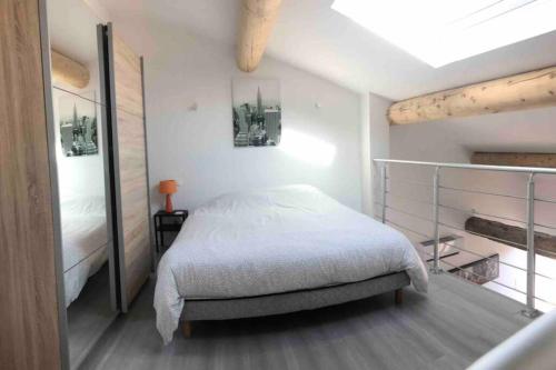 une chambre blanche avec un lit et une fenêtre dans l'établissement Charmante maison à 5min de Marcoule, à Codolet