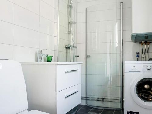 La salle de bains blanche est pourvue d'une douche et d'un lave-linge. dans l'établissement Holiday home STRÖMSTAD XVIII, à Strömstad