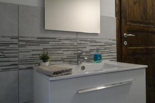 a bathroom with a white sink and a mirror at Corona Bed & Breakfast in Sardara
