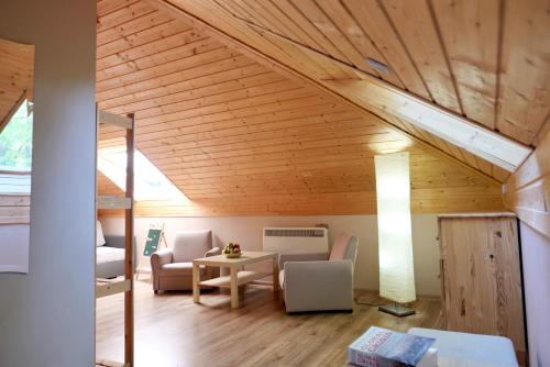 a living room with wooden ceilings and a table and chairs at Apartament Gaja in Poddąbie