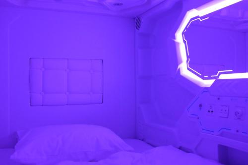 a bed with a purple light in a room at AV-1 Capsule Hotel in Kyiv