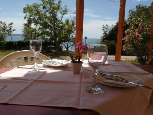 a table with two wine glasses on top of it at Apartmani nana in Starigrad-Paklenica