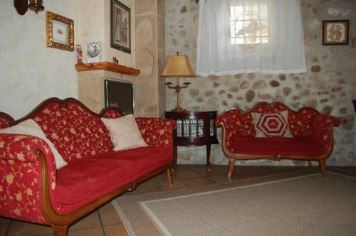 a living room with two red couches and a fireplace at HOTEL RURAL EL DENARIO in Garray