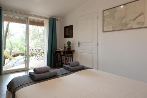 a bedroom with a bed and a door with a balcony at Maison Tavolara in Porto-Vecchio
