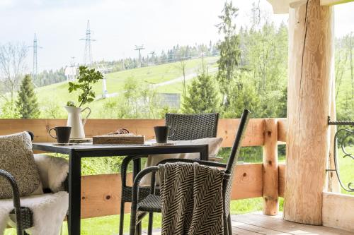 a patio with a table and chairs on a balcony at Domki w Białce WOODHOUSE- Twój górski azyl przy stoku in Białka Tatrzańska