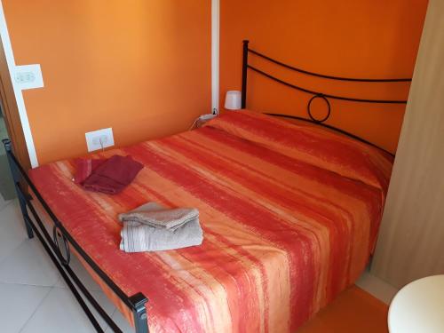 Ce lit se trouve dans un dortoir doté d'un mur orange. dans l'établissement B&B Panorama Cagliari, à Cagliari