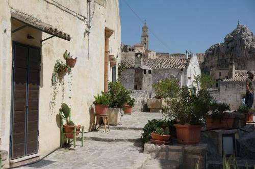 an alley with potted plants and a building at Il Geco in Matera