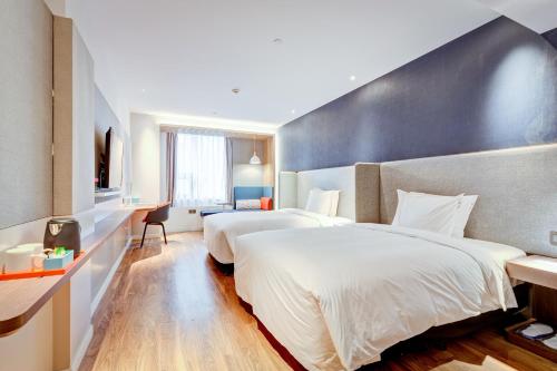 a hotel room with two beds and a desk at Holiday Inn Express Xi'an Bell Tower by IHG in Xi'an