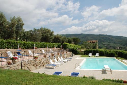 a swimming pool in a yard with lounge chairs around it at Borgo Sanguineto in Tuoro sul Trasimeno