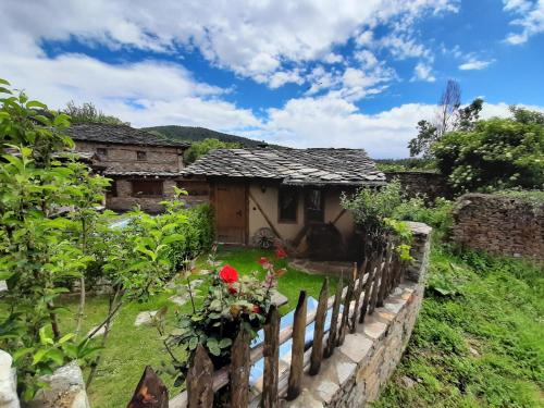 una casa vieja en un jardín con una valla en Скендерова Къща,къщичка Алиса en Leshten