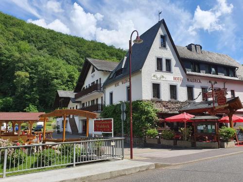 a large white building on the side of a street at Moselhotel Waldeck in Burgen