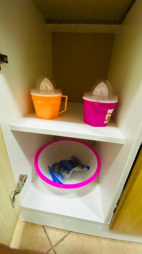 a white shelf with two baskets and a plate in a refrigerator at Cabañas Del Maule II in Talca