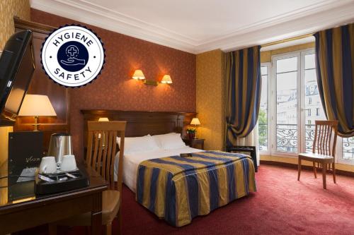 パリにあるホテル ヴィアトール ガールドリヨンのベッドとデスクが備わるホテルルームです。